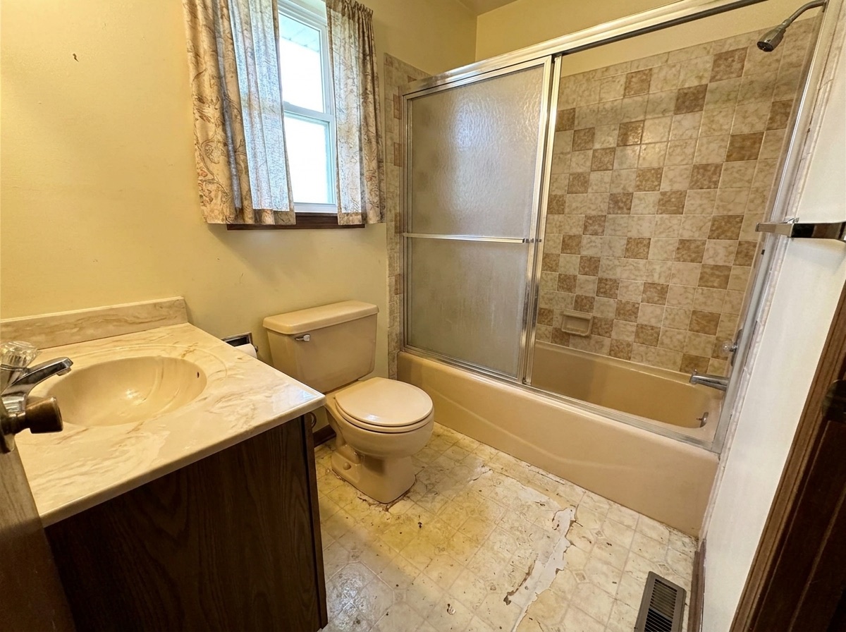 Dated almond-colored bathroom before remodeling