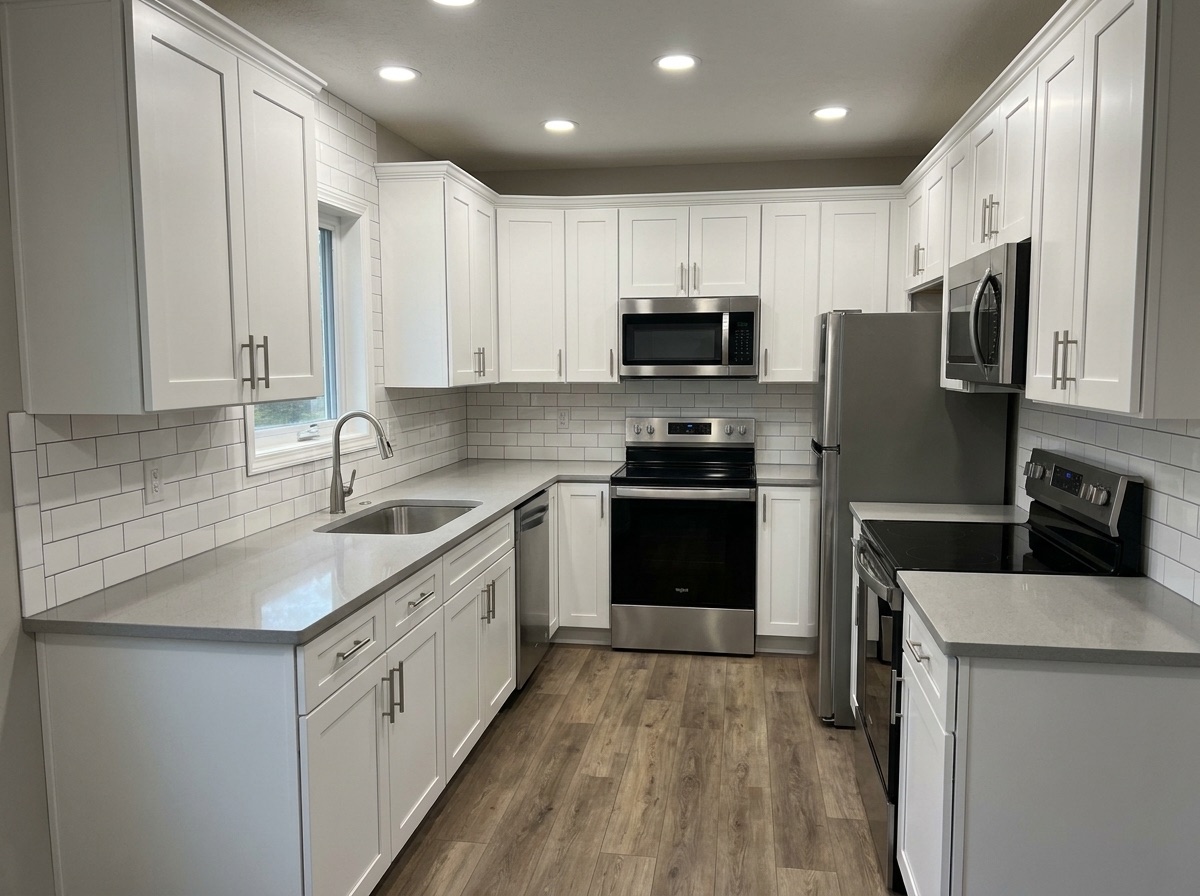 Bright remodeled kitchen with white shaker cabinets and quartz counters